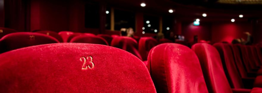 A row of red velvet seats in an opera theater