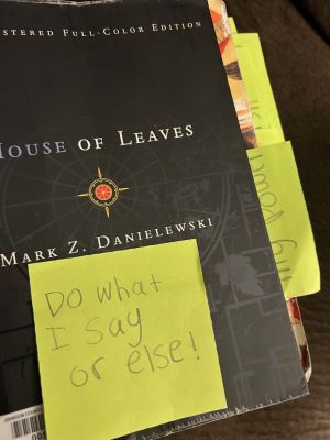 House of Leaves book with a yellow post it note reading "Do what I say or else!"